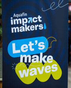 Een banner tijdens een event waar opstaat: Aquafin impact makers, let's make waves